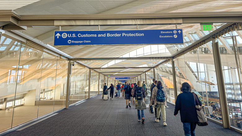 Travelers walking towards US Customs and Border Protection at Los Angeles International Airport