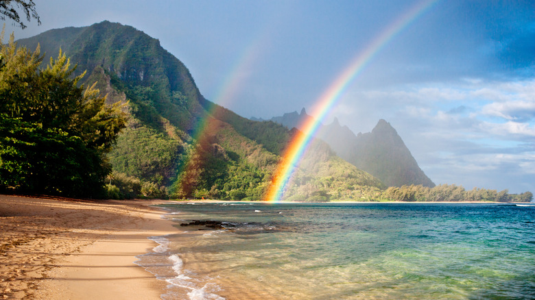 The beach on a Hawaiian island with a rainbow shining over the sea