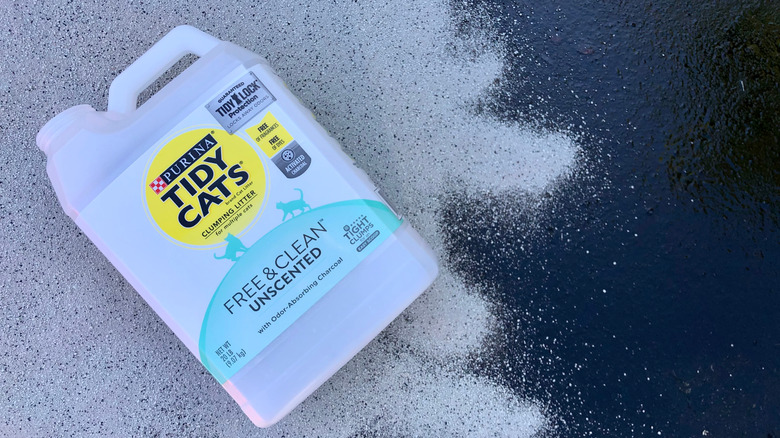 Cat litter spread over oil spill with Tidy Cats cat litter container