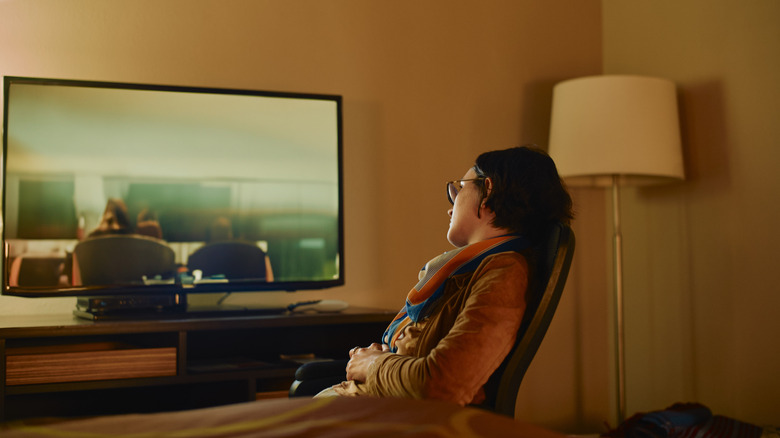 Woman watching TV in hotel room