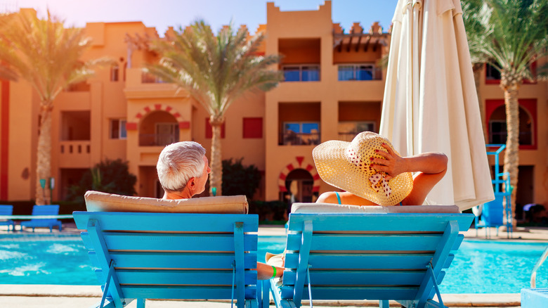 Couple relaxing by resort pool