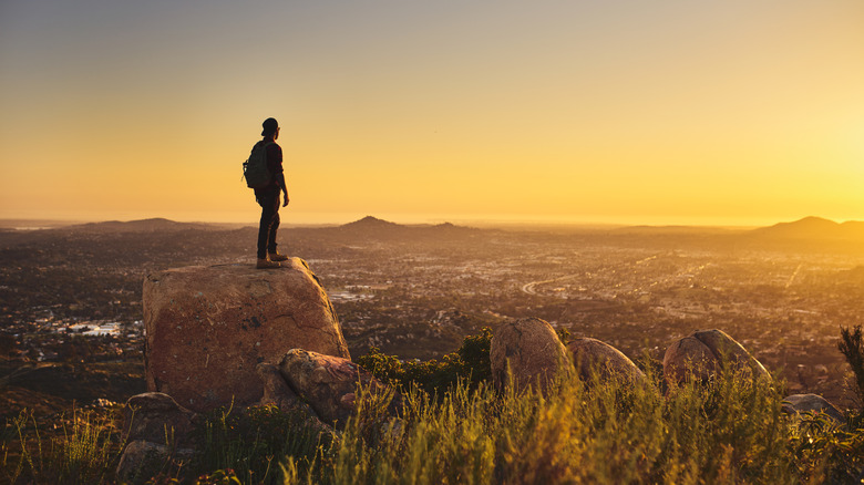 Hiker looking out over San Diego at Sunset