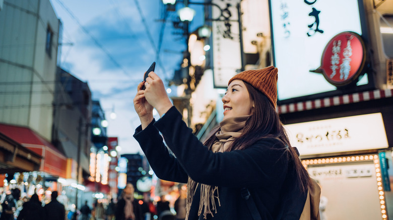 Woman taking pics in Osaka, Japan