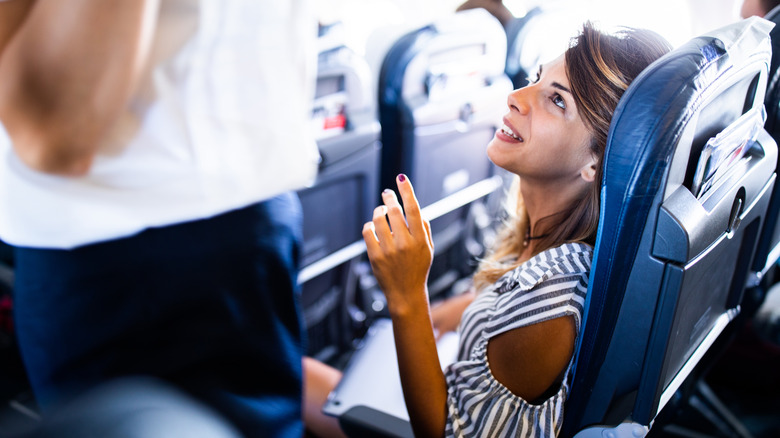 Flight attendant talking to passenger