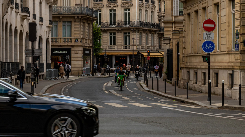 Busy Parisian street with street signs for bikes