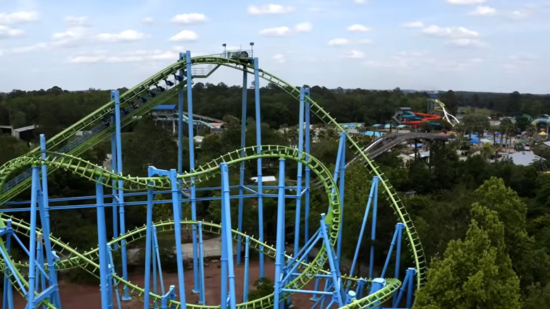 Areal view of a green and blue roller coaster with other rides in the background at Wild Adventures Park in Valdosta, Georgia