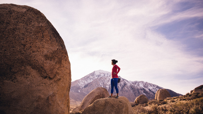 Woman standing on rock in Buttermilk Country, California