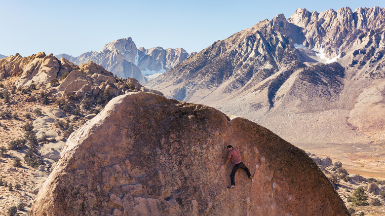 Man climbs boulder in Buttermilk Country, California