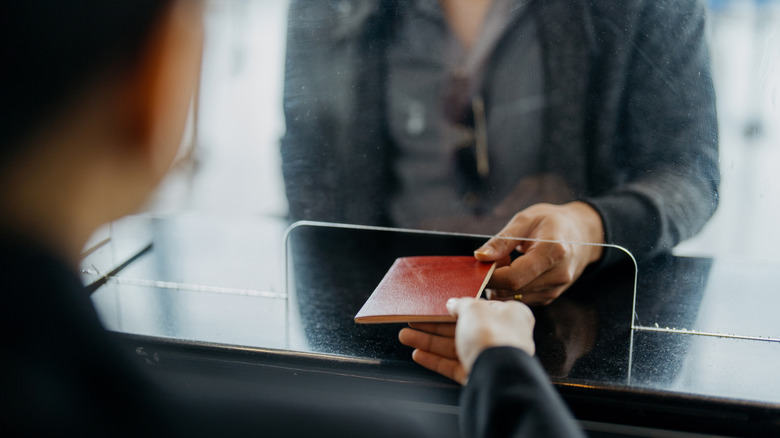 A traveler passing on a passport for inspection