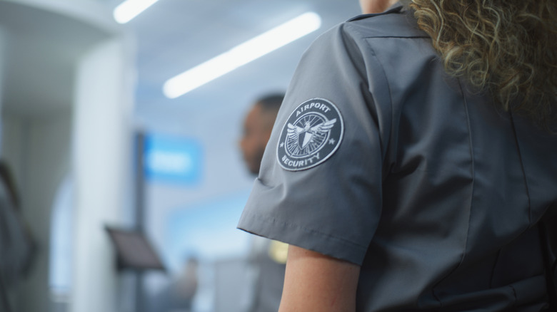 An airport security officer standing by the security checkpoint