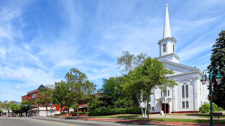 White steepled church in downtown Willimantic on sunny day