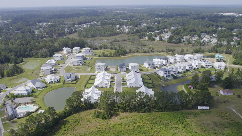 aerial view of neighborhood of big homes situated around ponds