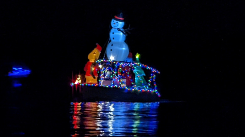 A boat decked out in Christmas decorations and lit up at night
