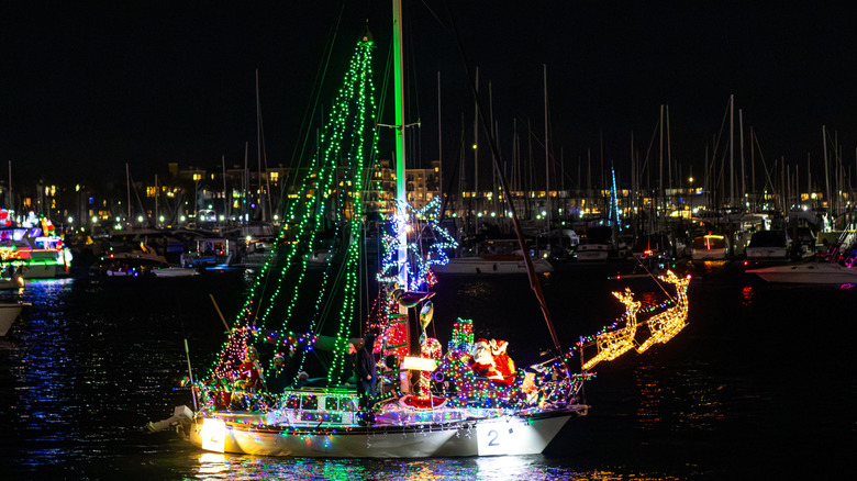 A sailboat decorated with festive holiday lights