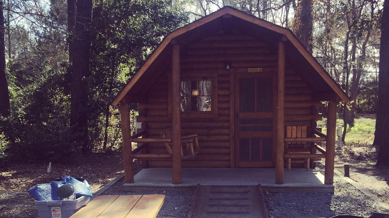 log cabin with trees behind it