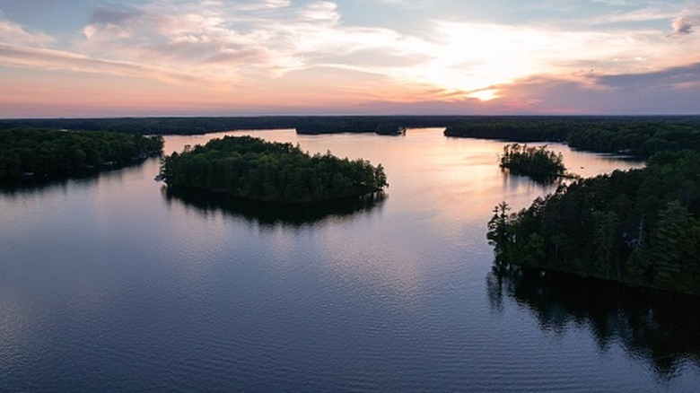 The calm water of Lake Minocqua reflecting the sunset with silhouetted islands in Wisconsin