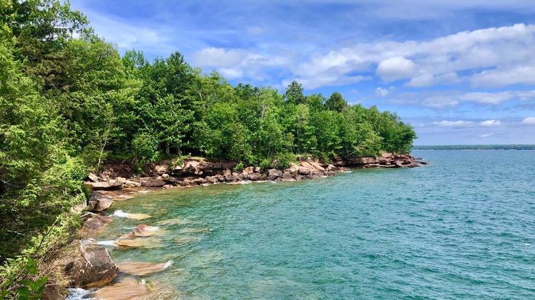 Madeline Island's rocky, tree-covered shore along Lake Superior's clear blue-green water