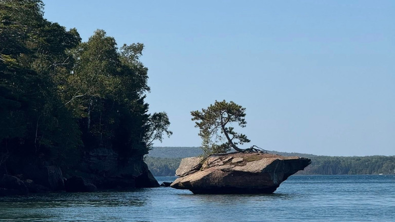 a large rock next to the cliffs of Oak Island, surrounded by Lake Superior's gentle waves