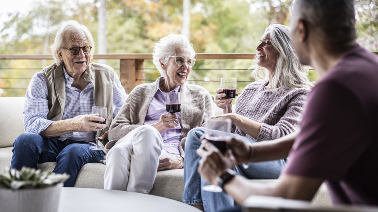 Senior citizens laughing with wine