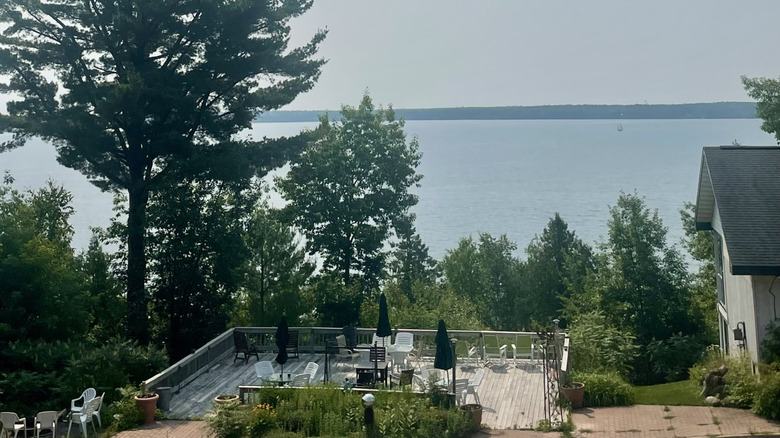 A deck with chairs, tables, and umbrellas overlooking Lake Superior