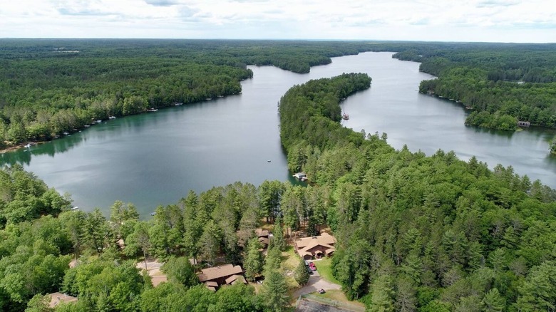 A few buildings and sprawling forest along the shores of Lake Owen