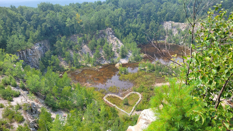 Heart-shaped rock art, surrounded by greenery and water, at Rib Mountain Quarry