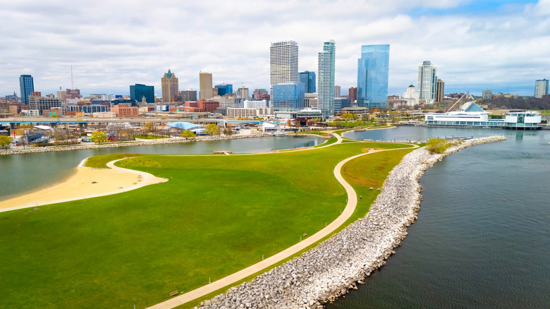 The Milwaukee city skyline seen from the green prairies, lagoon, pathways and beach at Lakeshore State Park.