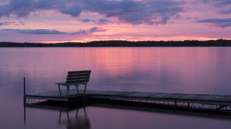 Bench on dock on a large, peaceful lake at sunset in Wisconsin