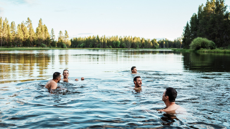 Male friends swimming in a lake