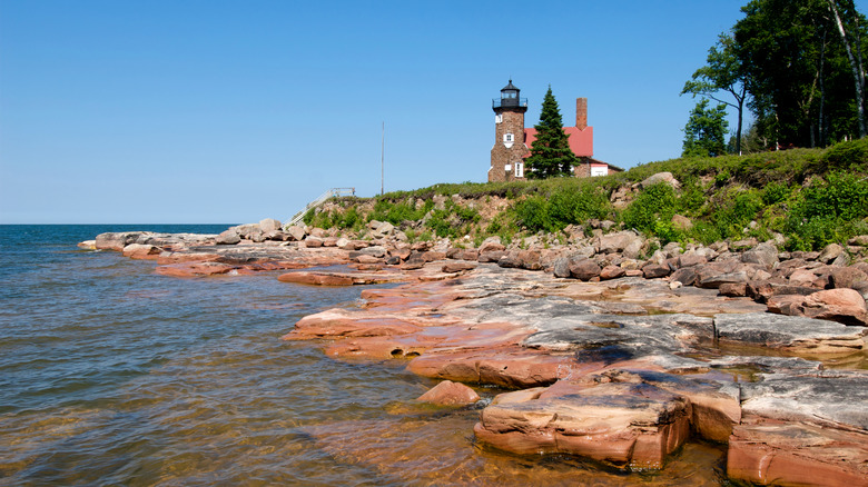Red rock shores of Sand Island with lightouse in background