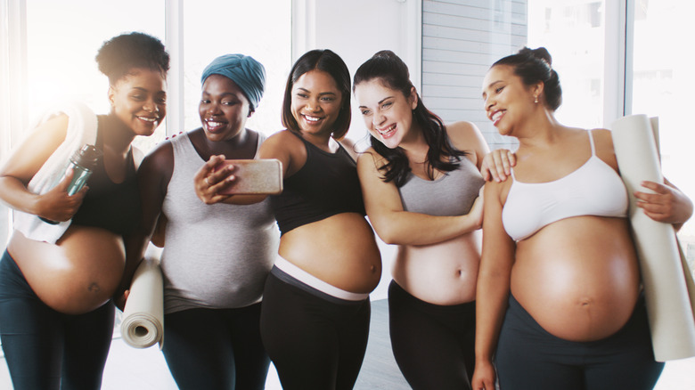 Diverse group of pregnant women taking a selfie together after a yoga session.