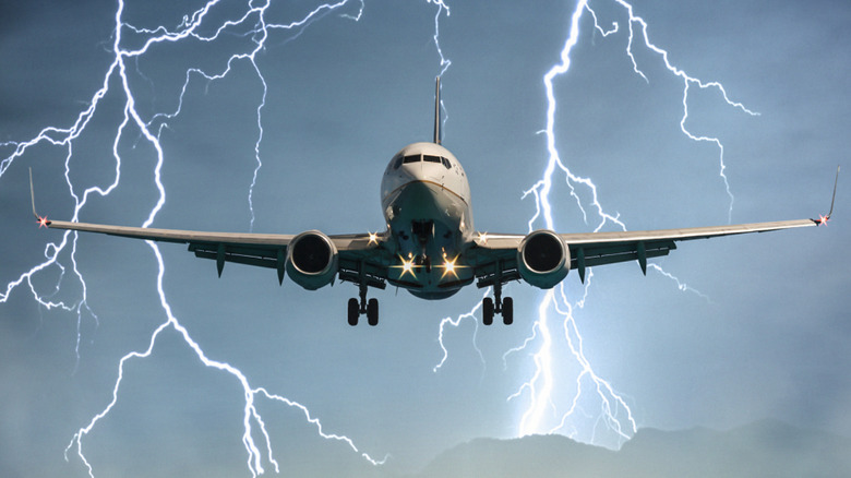 An airplane landing on a runway in stormy weather.