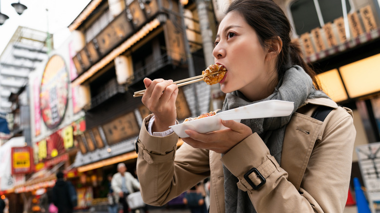 Woman eating with chopsticks