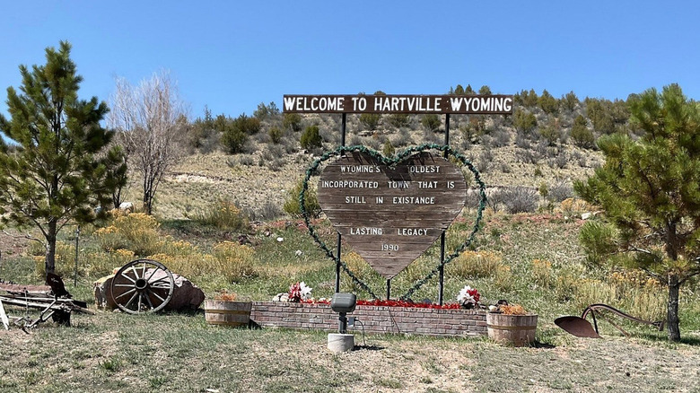 A heart-shaped wooden sign to the town of Hartville Wyoming against hills