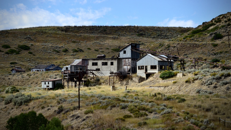 Abandoned mining complex on a grassy, hilly landscape, Wyoming