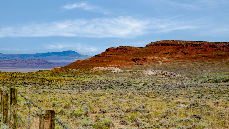 Red rock formation with mountains in the background in Wyoming