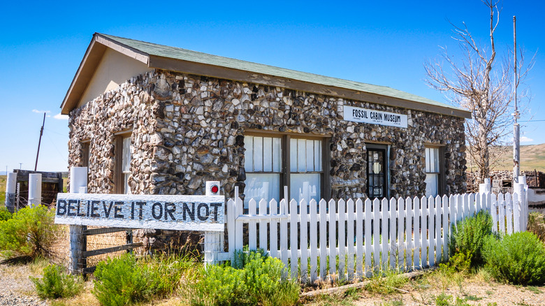 The Fossil Bone Cabin in Wyoming, with thousands of dinosaur bones covering the exterior and a sign up front that 