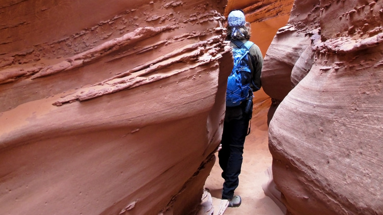 A hiker inside a narrow passage in Spooky Gulch in Utah