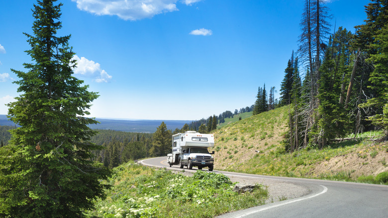 An RV driving on a picturesque road through Yellowstone National Park