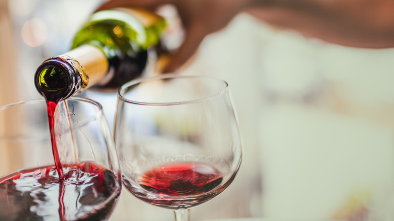 Person pouring glass of wine