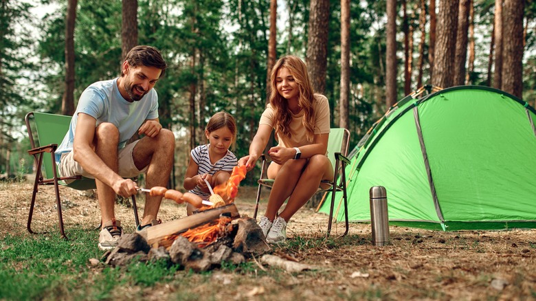 Family cooking food on a campfire