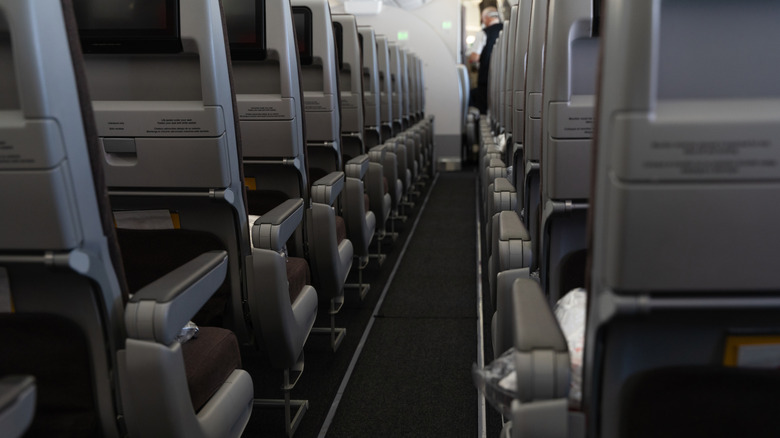 A forward facing photos up the aisle of a plane with empty seats