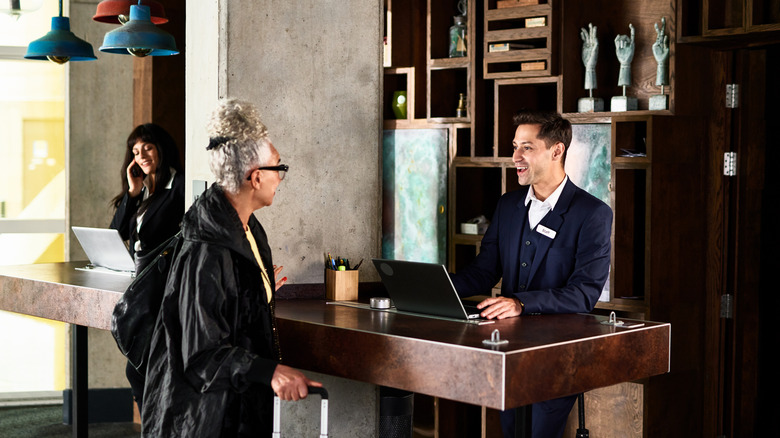 Woman checking in at hotel reception