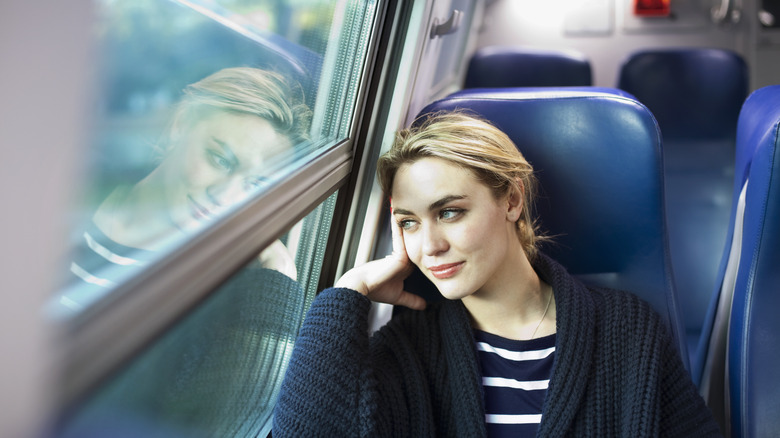 Woman looking out window of train