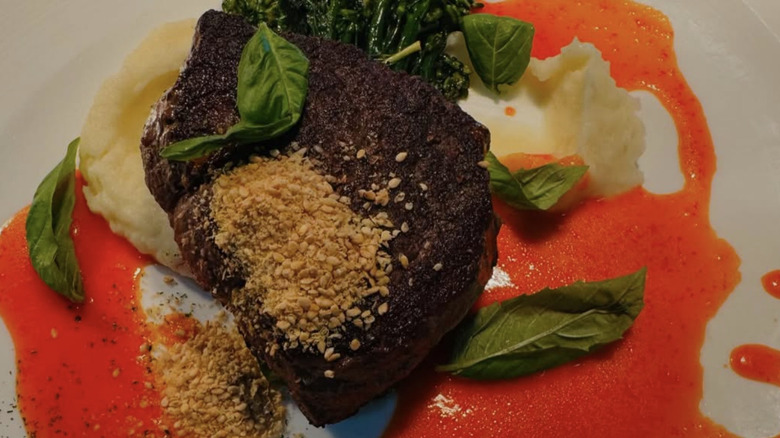 Seared steak with glaze on a white plate