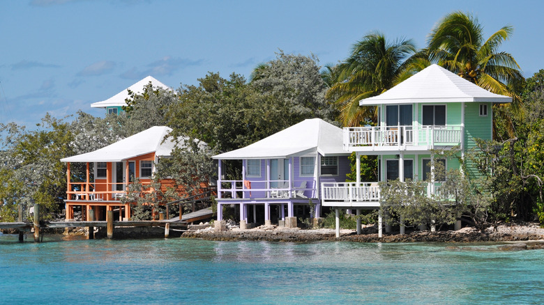 View of orange, purple, and mint green bungalows sitting on the water