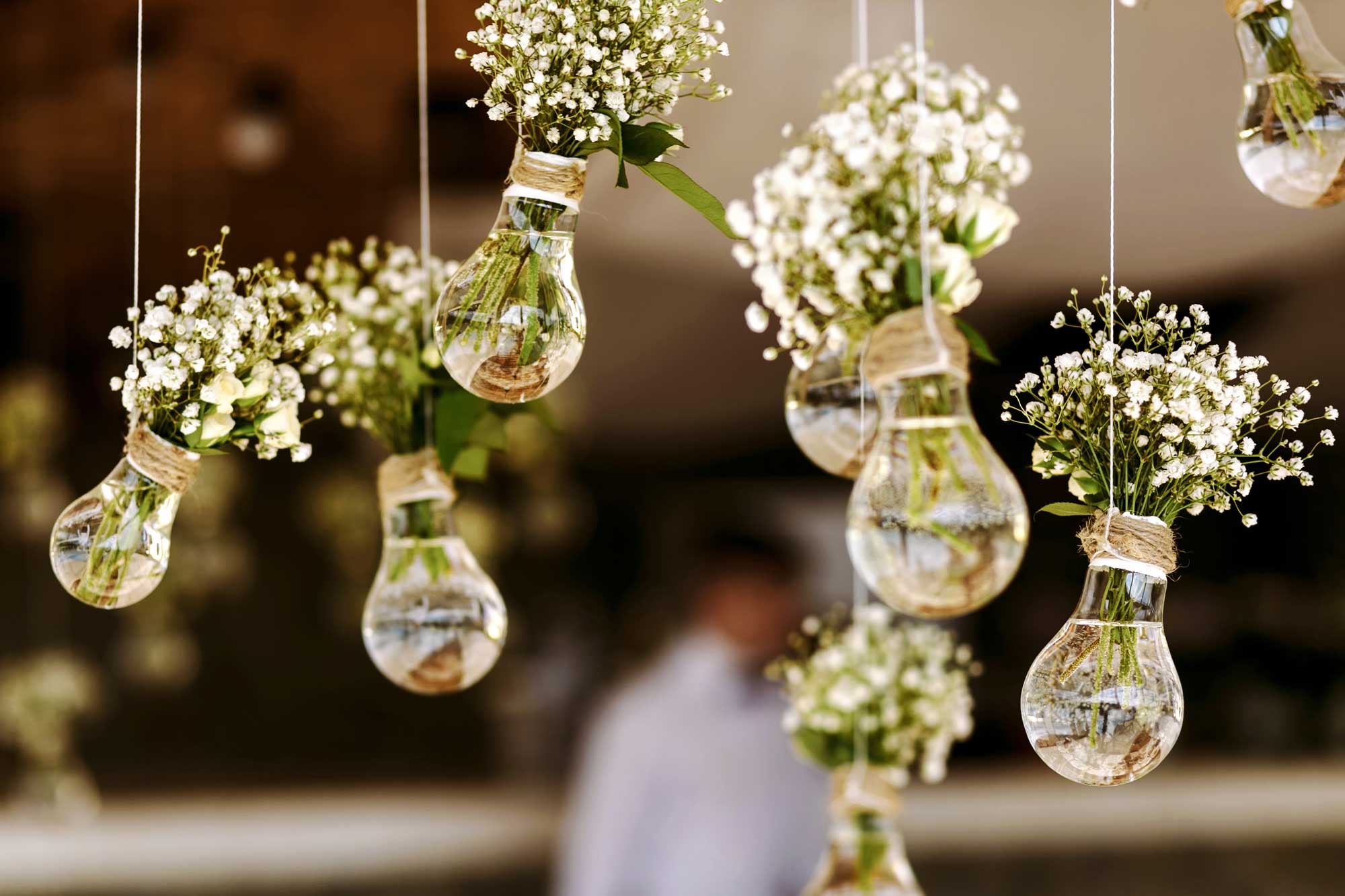 Flower-filled lightbulbs hanging over reception tables