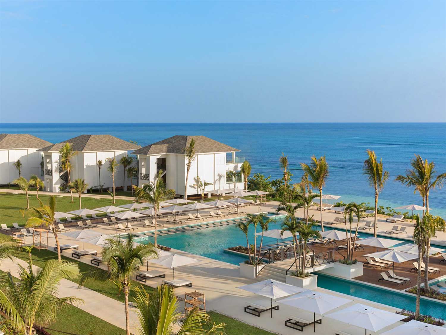 Aerial photo of a pool resort by the ocean.