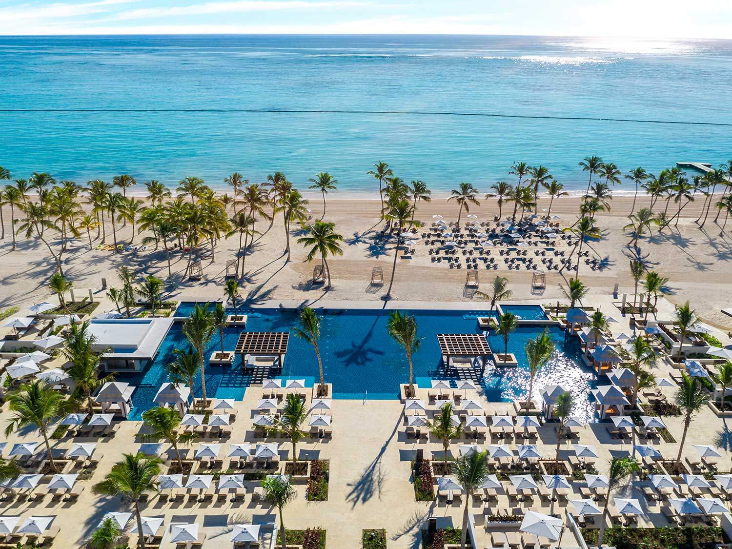 Pool spa lounges next to a pool by the ocean.