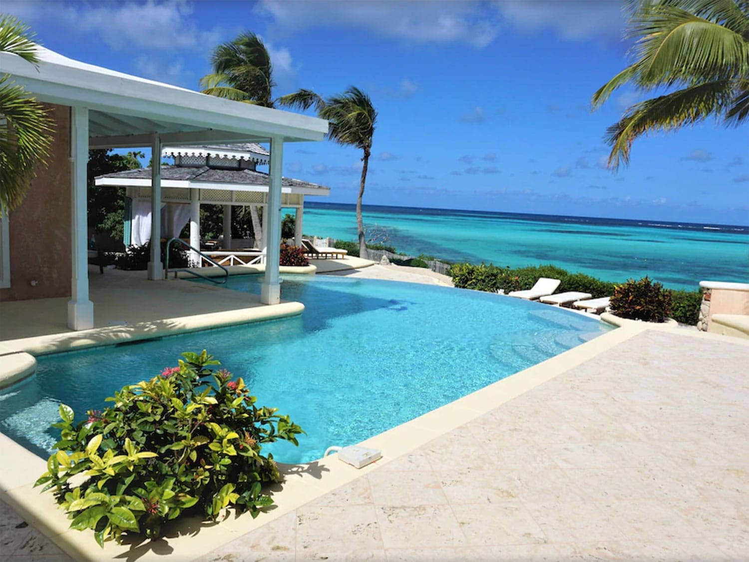 A resort-style home with an outdoor pool next to a beach.